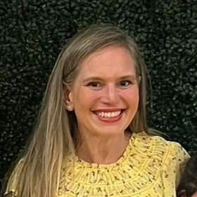 Michele smiling happily in a yellow dress