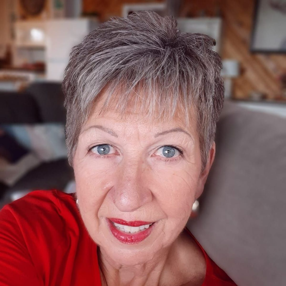A woman with gray hair in a red shirt.